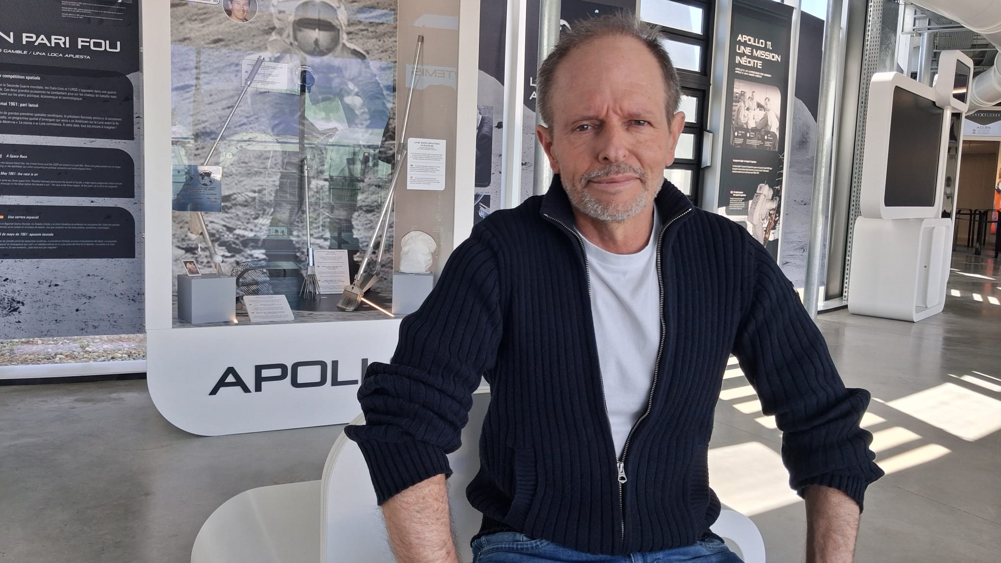 Bernard Minier, l'auteur français assis dans le hall d'accueil du LuneXplorer à la Cité de l'espace